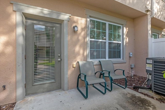 property entrance with cooling unit and a patio