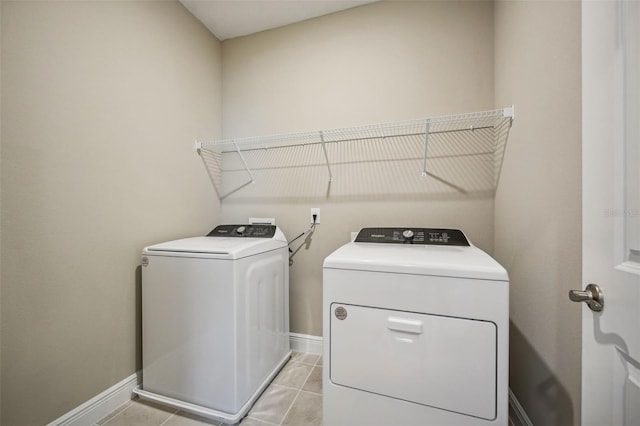 washroom featuring washer and clothes dryer and light tile patterned flooring