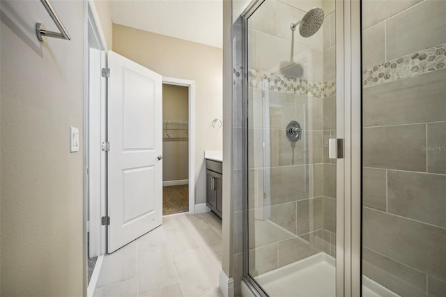 bathroom with tile patterned flooring, vanity, and a shower with door