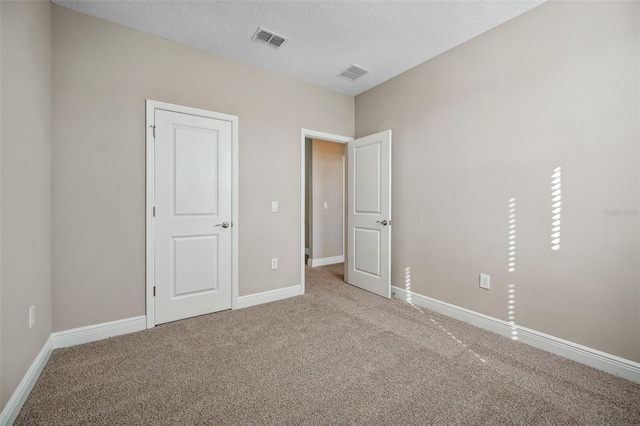 unfurnished bedroom featuring carpet and a textured ceiling