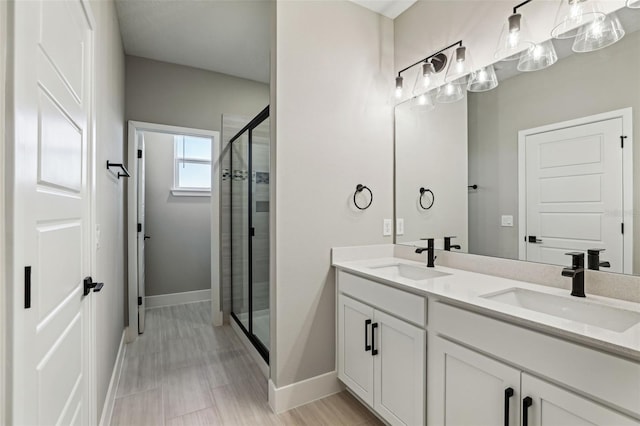 bathroom featuring hardwood / wood-style flooring, vanity, and an enclosed shower