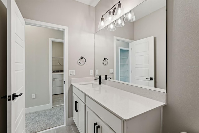 bathroom with tile patterned flooring, vanity, and washer / dryer