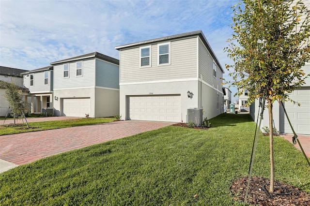 view of front of property with central AC, a garage, and a front lawn