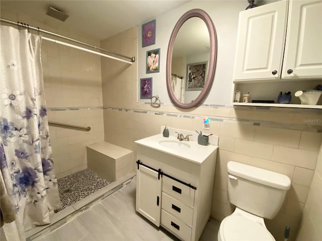 bathroom with vanity, tile walls, a shower with shower curtain, and toilet