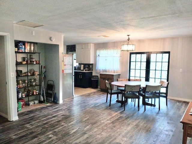 dining room with a notable chandelier, hardwood / wood-style flooring, and a textured ceiling