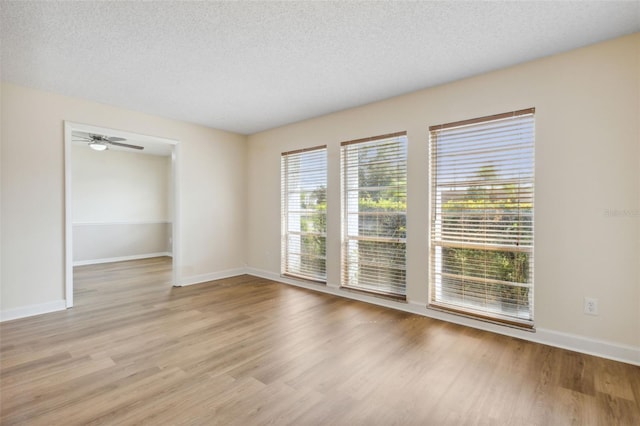 unfurnished room with ceiling fan, a textured ceiling, and light hardwood / wood-style flooring