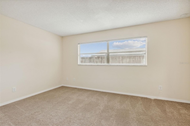 empty room featuring carpet, a textured ceiling, and a healthy amount of sunlight