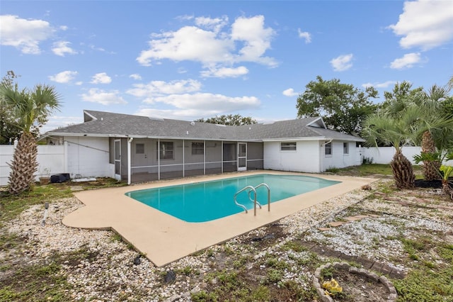 view of pool with a sunroom and a patio