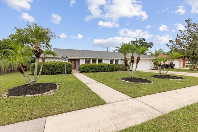 ranch-style home featuring a garage and a front lawn