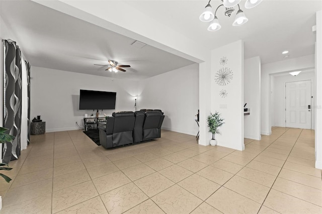 tiled living room featuring ceiling fan with notable chandelier