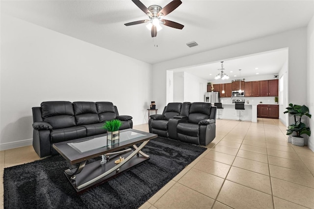 living room featuring ceiling fan with notable chandelier and light tile patterned floors