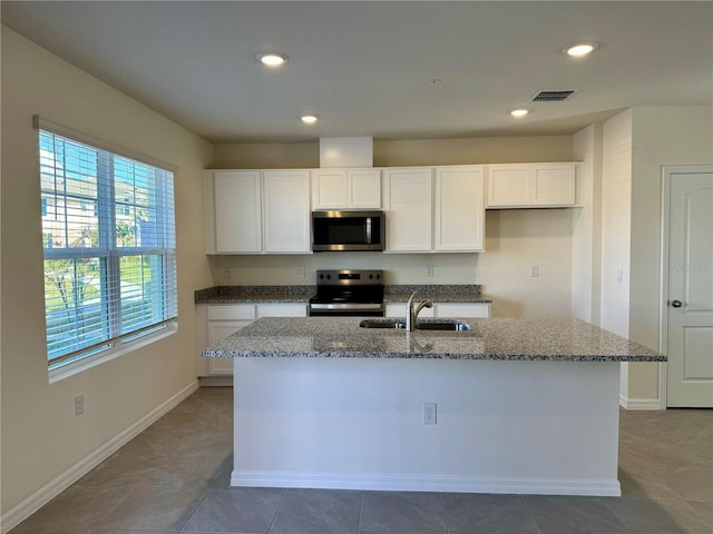 kitchen featuring a kitchen island with sink, white cabinets, sink, light stone countertops, and appliances with stainless steel finishes