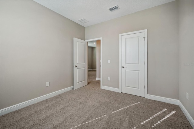 unfurnished bedroom with carpet floors and a textured ceiling