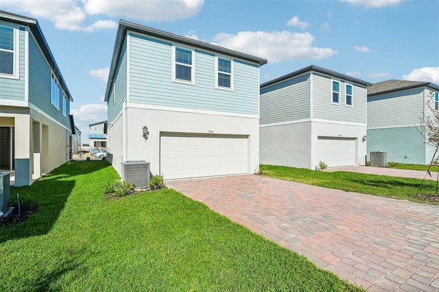 view of front facade featuring central AC, a garage, and a front lawn