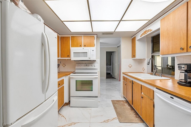 kitchen with ornamental molding, white appliances, tasteful backsplash, and sink