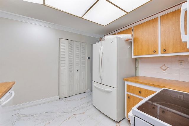 kitchen with white refrigerator, stove, ornamental molding, and tasteful backsplash