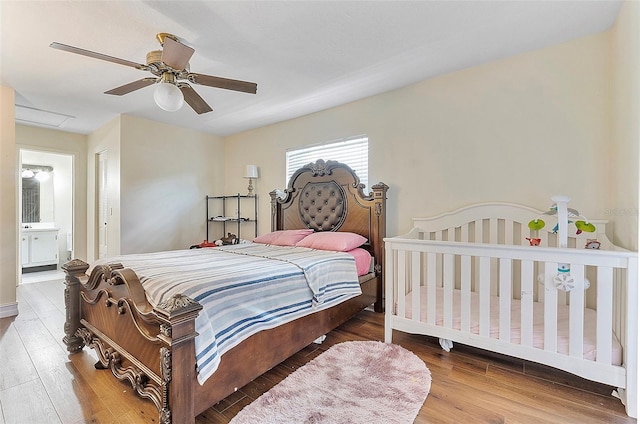 bedroom with ceiling fan, hardwood / wood-style flooring, and connected bathroom