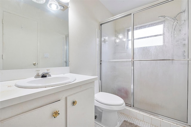 bathroom with vanity, tile patterned flooring, toilet, and an enclosed shower