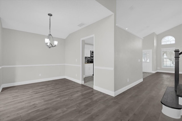 unfurnished dining area with an inviting chandelier, dark wood-type flooring, and vaulted ceiling