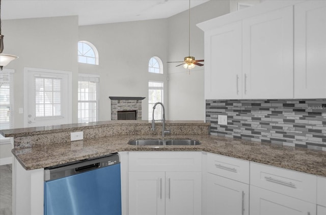 kitchen with stainless steel dishwasher, white cabinetry, sink, and ceiling fan