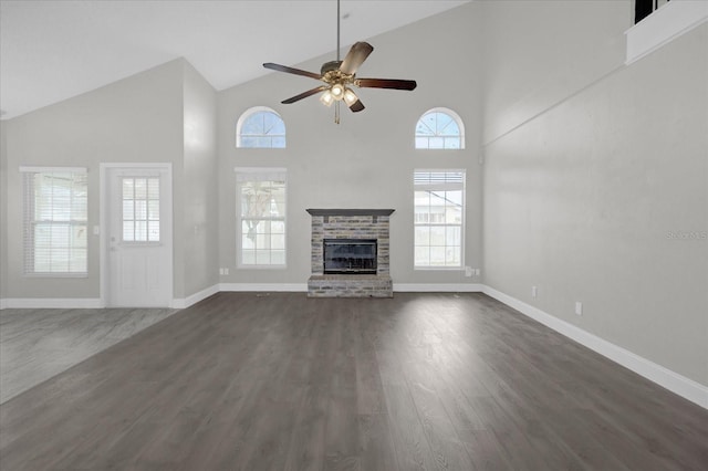 unfurnished living room with a fireplace, baseboards, dark wood-type flooring, and ceiling fan