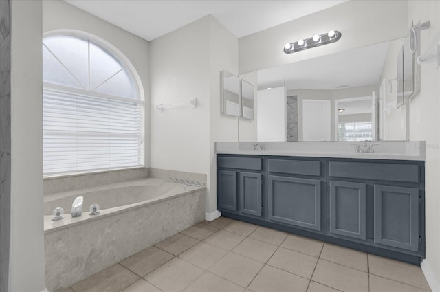 bathroom featuring tiled tub, vanity, and tile patterned flooring