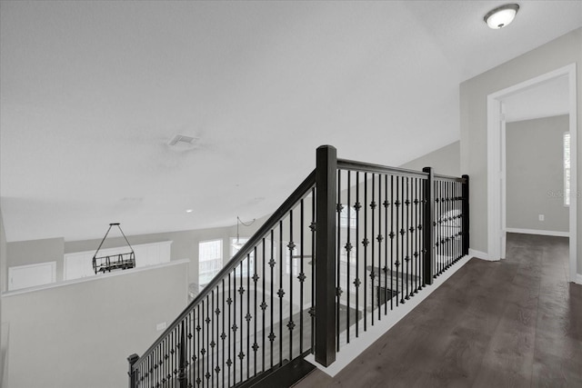 staircase featuring baseboards and wood finished floors