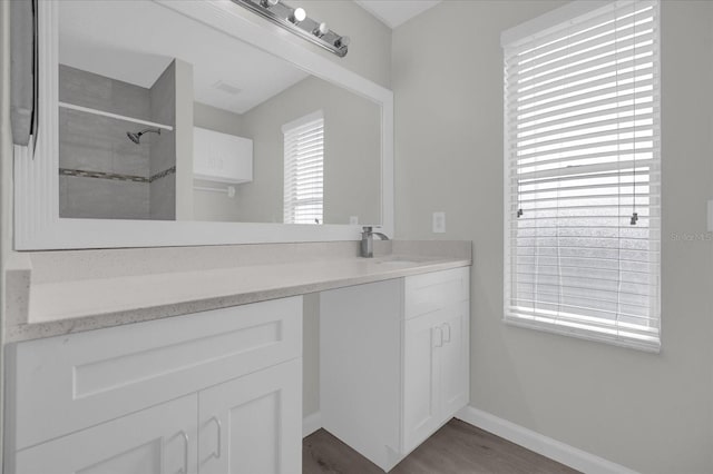 bathroom featuring vanity, a tile shower, and hardwood / wood-style flooring