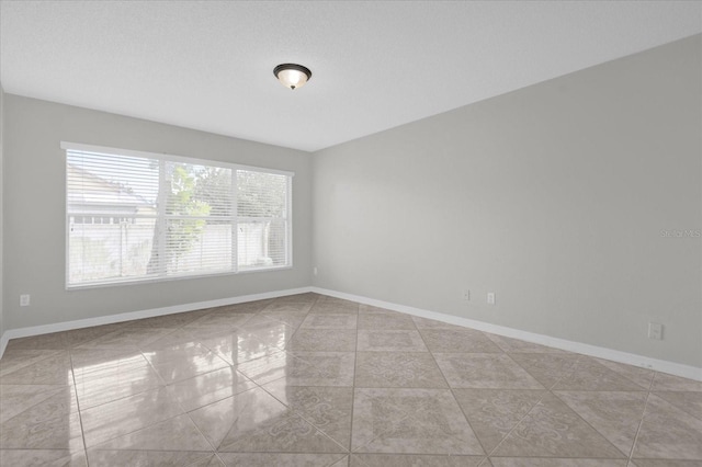 tiled spare room with a textured ceiling