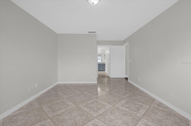 unfurnished room featuring baseboards and visible vents