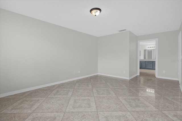 unfurnished room with baseboards, visible vents, and light tile patterned flooring