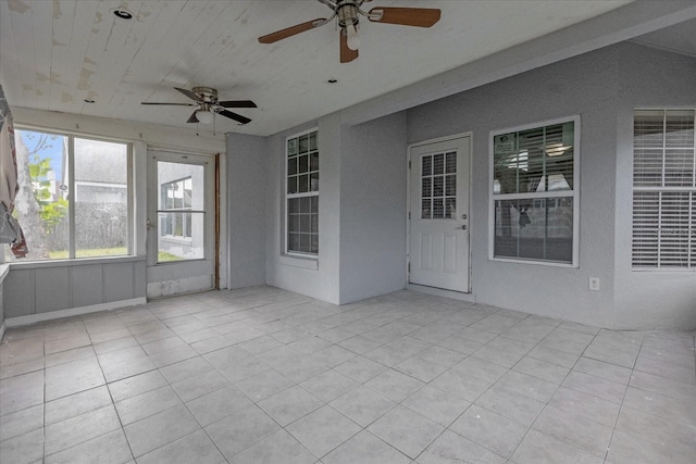 unfurnished sunroom with ceiling fan