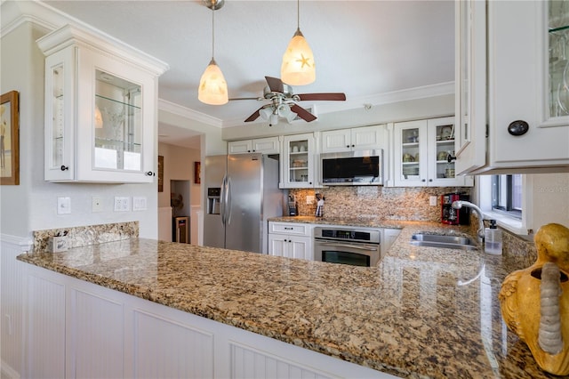 kitchen with appliances with stainless steel finishes, white cabinetry, crown molding, ceiling fan, and sink