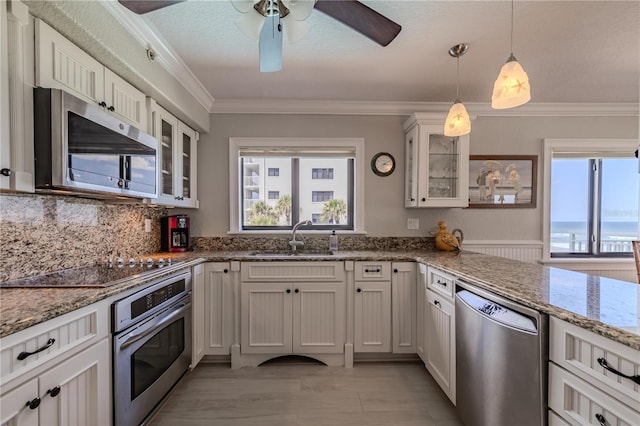 kitchen featuring sink, white cabinets, appliances with stainless steel finishes, light stone countertops, and ceiling fan