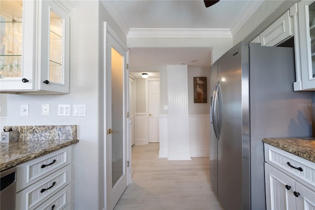 kitchen featuring ornamental molding, white cabinetry, appliances with stainless steel finishes, and stone countertops