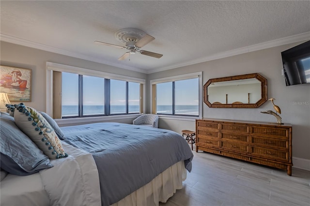 bedroom with a textured ceiling, light hardwood / wood-style flooring, a water view, crown molding, and ceiling fan