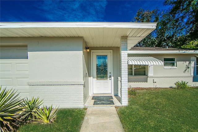 doorway to property featuring a garage and a yard