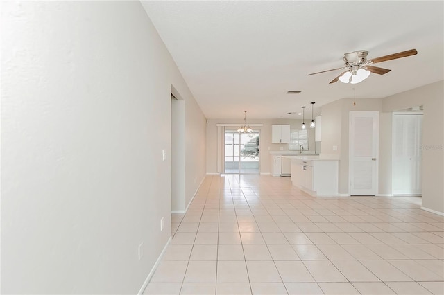 unfurnished living room with ceiling fan with notable chandelier, light tile patterned flooring, and sink