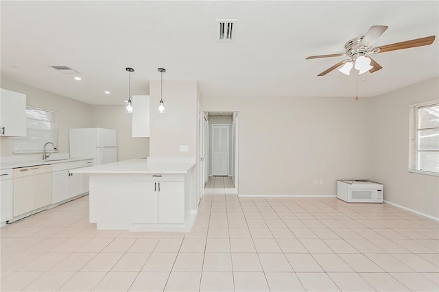 kitchen featuring white appliances, sink, hanging light fixtures, ceiling fan, and white cabinetry