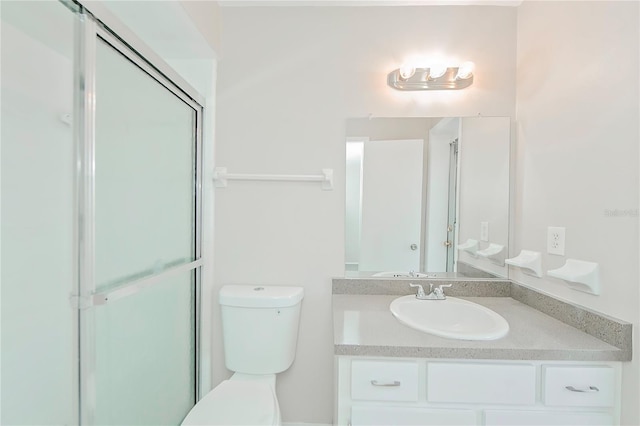 bathroom with vanity, toilet, and a shower with shower door