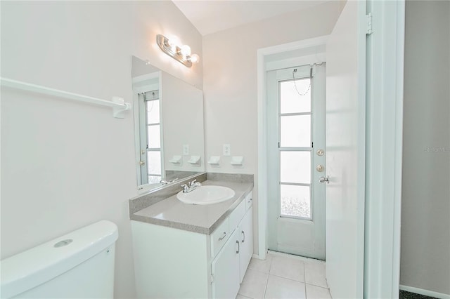 bathroom with toilet, vanity, tile patterned floors, and a healthy amount of sunlight