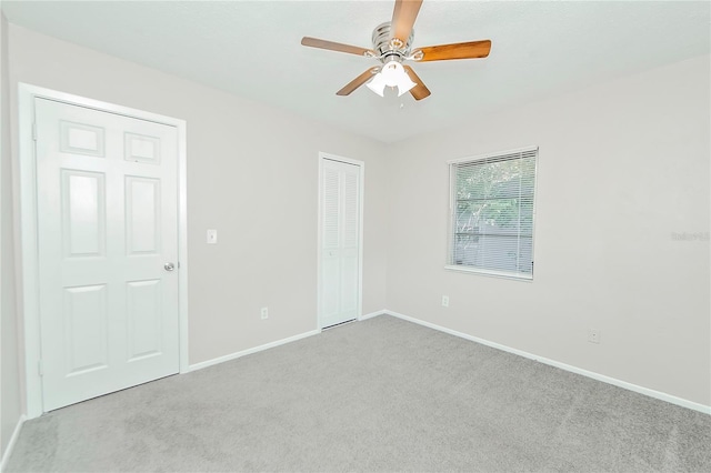 unfurnished bedroom with ceiling fan, a closet, and light colored carpet