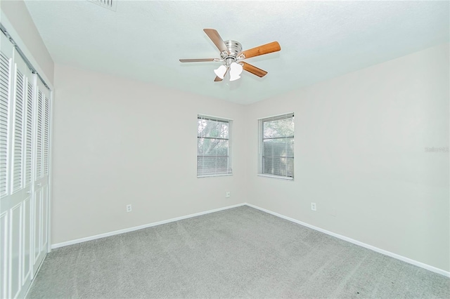 unfurnished bedroom with ceiling fan, light carpet, and a closet