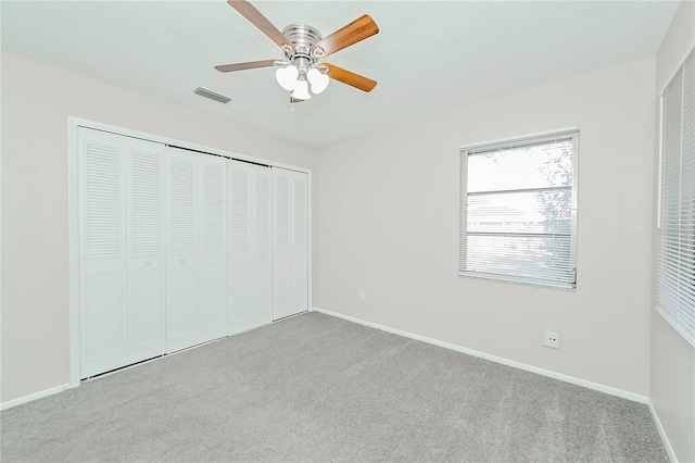 unfurnished bedroom with ceiling fan, light colored carpet, and a closet