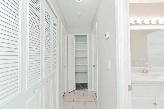 hall featuring light tile patterned floors and sink