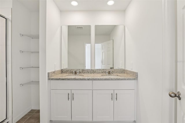 bathroom with vanity, a shower with shower door, and tile patterned floors