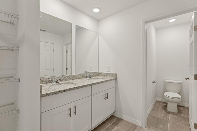 bathroom featuring vanity, toilet, and tile patterned flooring