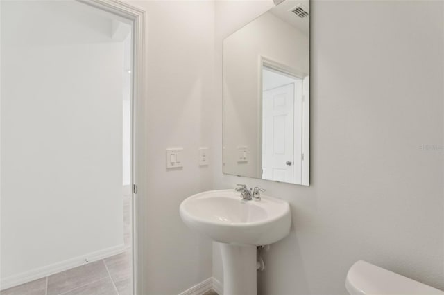 bathroom with toilet and tile patterned flooring