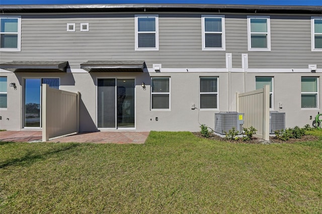 back of house featuring central AC unit, a lawn, and a patio