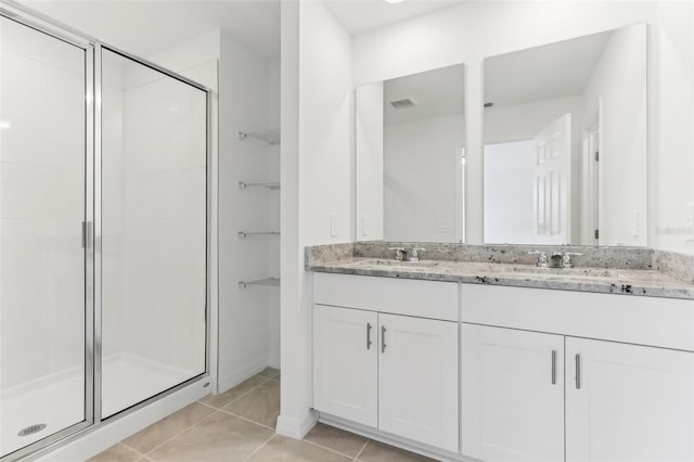 bathroom featuring vanity, a shower with door, and tile patterned floors